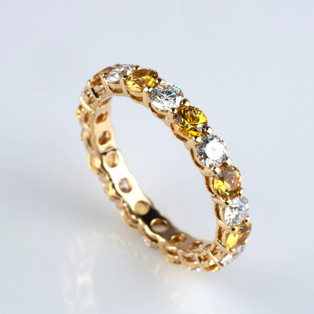 Alternating yellow and white diamond infinity yellow gold ring